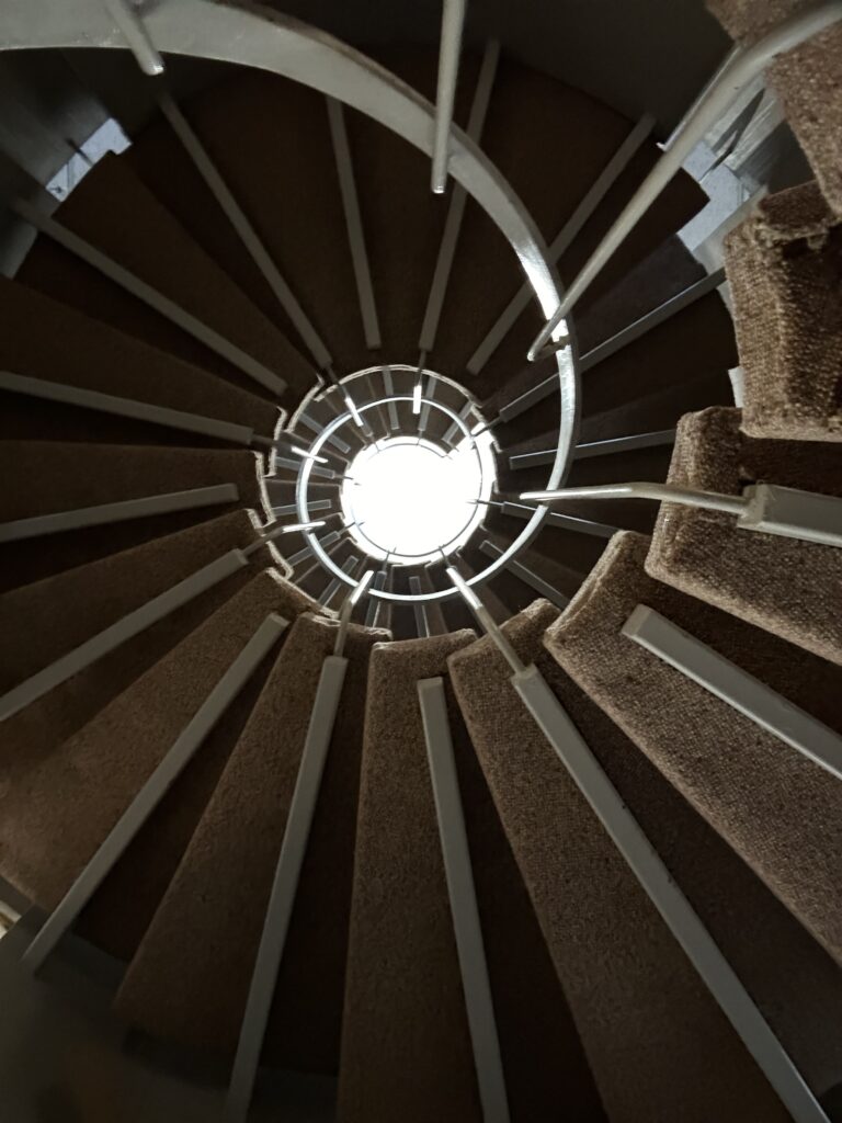 Looking up at a circular stairwell from the bottom